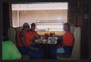 [Three crew members eating breakfast in a wooden booth: Lone Star Ride 2003 event photo]