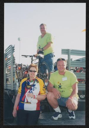 [Three people unloading a bike trailer: Lone Star Ride 2003 event photo]