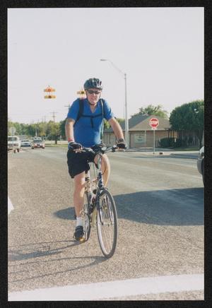 [Cyclist in blue stopped at a road intersection: Lone Star Ride 2003 event photo]