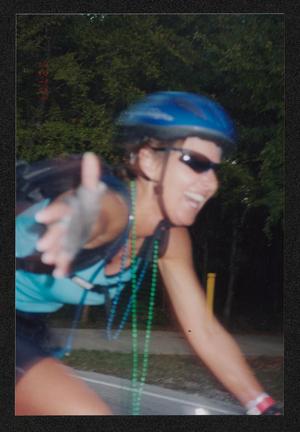 [Cyclist speeding by with her hand out: Lone Star Ride 2003 event photo]