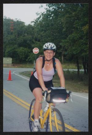 [Slightly blurred cyclist riding into the camping area at the end of day #1: Lone Star Ride 2003 event photo]