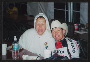Primary view of object titled '[Two individuals seated at long banquet table eating breakfast: Lone Star Ride 2003 event photo]'.