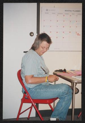 [Individual sitting in a red fold-out chair: Lone Star Ride 2004 event photo]