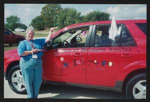 [Woman posing by a red mid-size car: Lone Star Ride 2004 event photo]