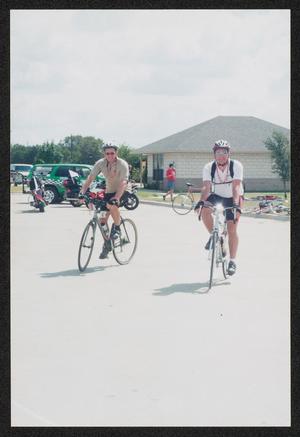 [Two cyclists in a rest stop parking lot: Lone Star Ride 2004 event photo]