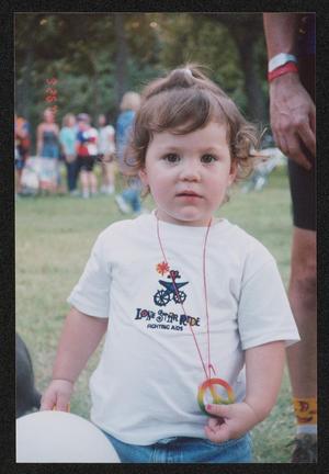 Primary view of object titled '[Young toddler wearing a peace sign necklace: Lone Star Ride 2004 event photo]'.