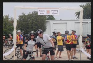 Primary view of object titled '[Cyclists #312 and #316 under a constructed archway: Lone Star Ride 2010 event photo]'.