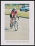 Thumbnail image of item number 1 in: '[Cyclist Valerie Ayala Bruce smiling as she cycles up a hill]'.