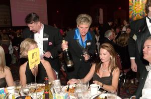 [Deiadra Burns offers champagne to Sheryl and Eric Maas, 2005 Black Tie Dinner]