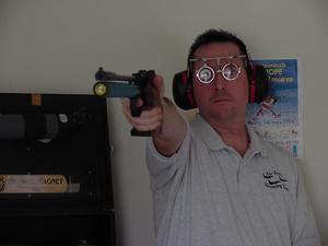 [Steve Swartz poses with air pistol, 1]