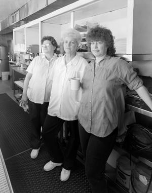 [Three women posing in a kitchen]