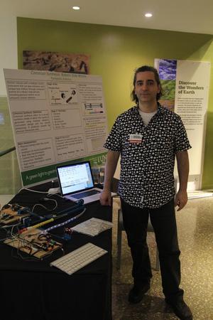 [Person standing next to science exhibit research poster, College of Music at the Perot Museum]