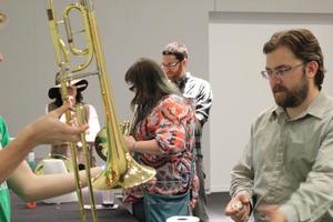 [Person learning how to play the trombone, College of Music at the Perot Museum]