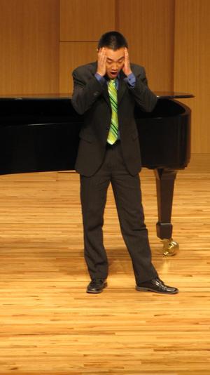 [Singer with green tie performing at the Student recital during Jake Heggie's residency, 3]