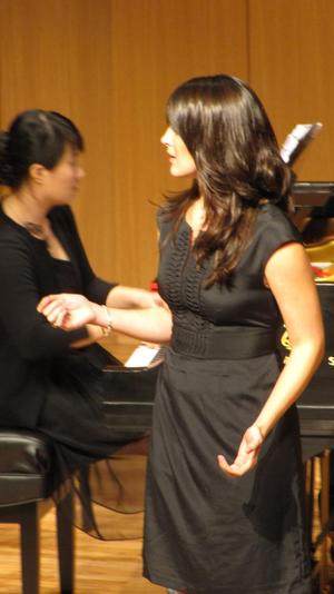 [Close-up of a singer wearing a black dress performing at the Student recital during Jake Heggie's residency]