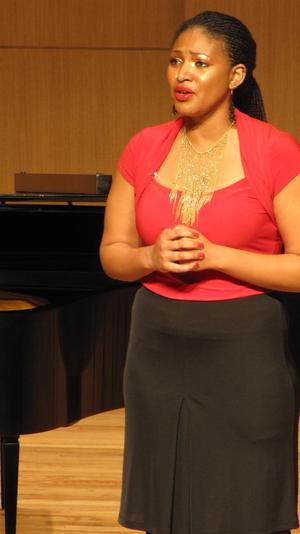 [Singer wearing a red blouse performing at the Student recital during Jake Heggie's residency, 1]