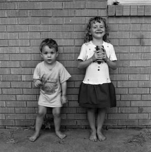 [Two children standing in front of a brick wall #1]