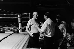 [Two men next to a boxing ring #1]