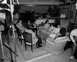[Mike Evans and others sit in living room, 1]