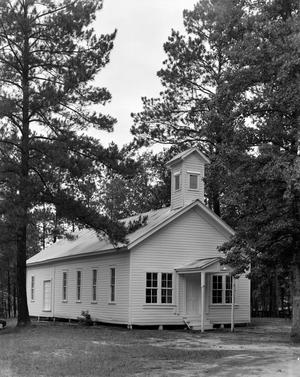 [A small church building in a wooded area]
