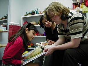 [Young girl reads to ILD tutors]