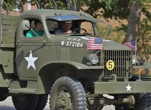 [Men drive military vehicle at 2011 Homecoming Parade]
