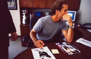 Primary view of object titled '[Mike Modano seated behind a desk and signing an autograph]'.