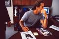 Photograph: [Mike Modano seated behind a desk and signing an autograph]