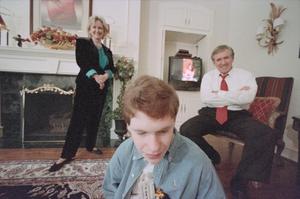 [Michael Rowlett and parents in their living room]