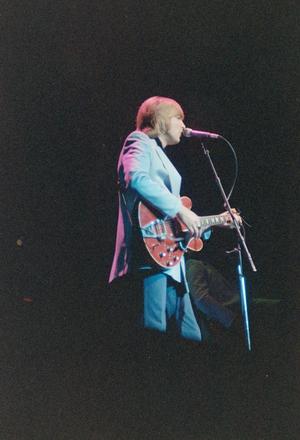[Side profile of Justin Hayward performing on stage]