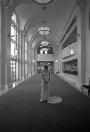 [Bridal model in a veil posing in the lobby of a large building]