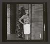 Primary view of [Woman posing in a pleated skirt and abstract-print top, 1]