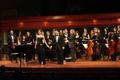 Photograph: [Haley Sicking and Kevin Park stand with Symphony Orchestra after "Nu…