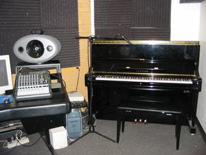 [Electronic equipment sitting on a table near a piano]