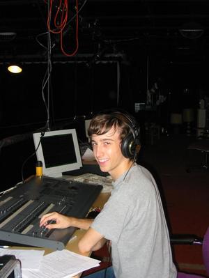 [A young man wearing headphones sitting at a sound board, 2]