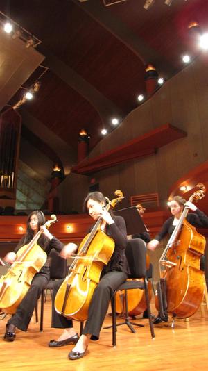 [Four students playing cellos and basses]