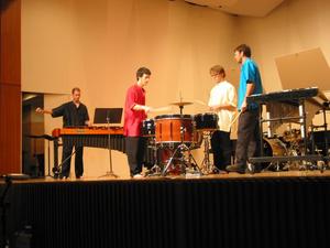 [Three men around a drum set and one man at a xylophone, 1]