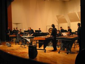 [A group of percussionists in black playing xylophones and drums onstage, 3]