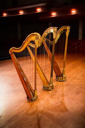 [Three decorated harps sitting on a stage]