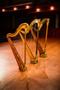 Photograph: [Three decorated harps sitting on a stage]