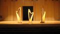 Photograph: [Three harps sitting at the center of a stage]