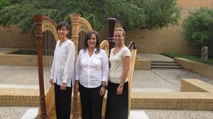 [Dr. Jaymee Haefner standing with two women in front of harps, 1]