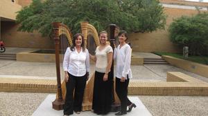 [Dr. Jaymee Haefner standing with two women in front of harps, 4]