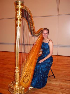 Primary view of object titled '[A woman in a blue dress sitting behind a harp]'.