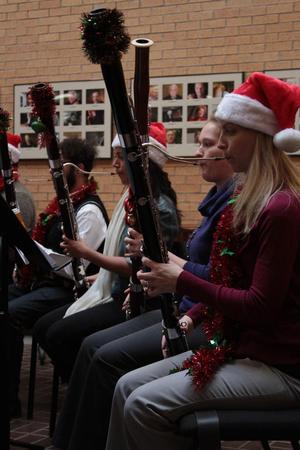 [A row of people playing bassoons adorned with tinsel, 2]