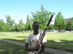 [A man in a white t-shirt posing with a bassoon, 1]