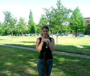 [A woman in a black tank top shirt posing with a bassoon, 1]