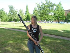 [A woman in a black tank top shirt posing with a bassoon, 2]