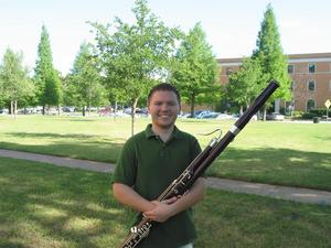 [A man in a green shirt posing with a bassoon, 1]