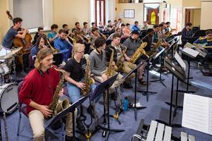 [Rows of woodwind and brass musicians performing in a room, 1]